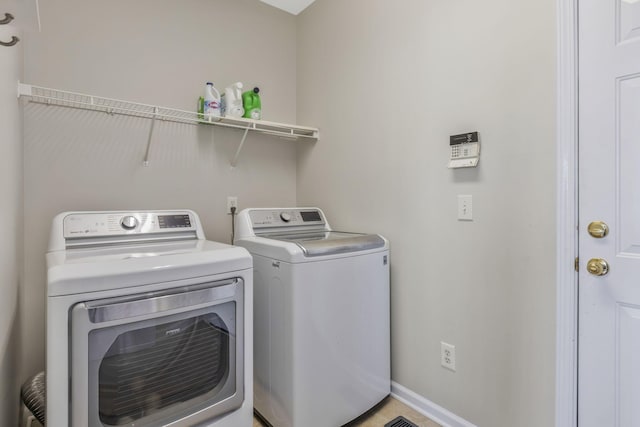 laundry area featuring baseboards, laundry area, and independent washer and dryer