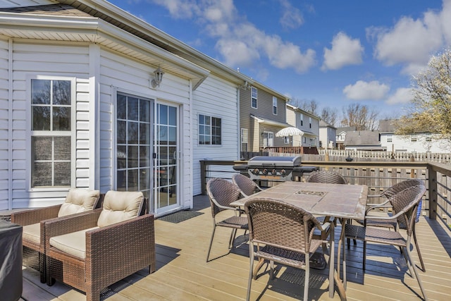 deck with outdoor dining area, a residential view, and area for grilling