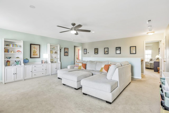 living area featuring a ceiling fan and light carpet
