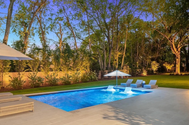 view of swimming pool featuring a lawn, fence, a fenced in pool, and a patio area