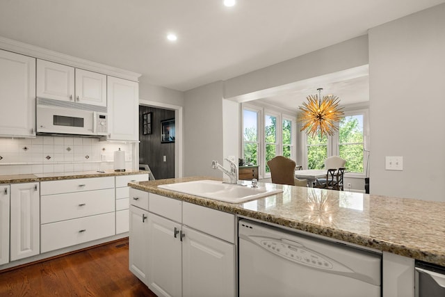 kitchen featuring a sink, white cabinets, recessed lighting, white appliances, and dark wood-type flooring