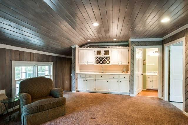sitting room featuring crown molding, wooden walls, light carpet, recessed lighting, and wooden ceiling