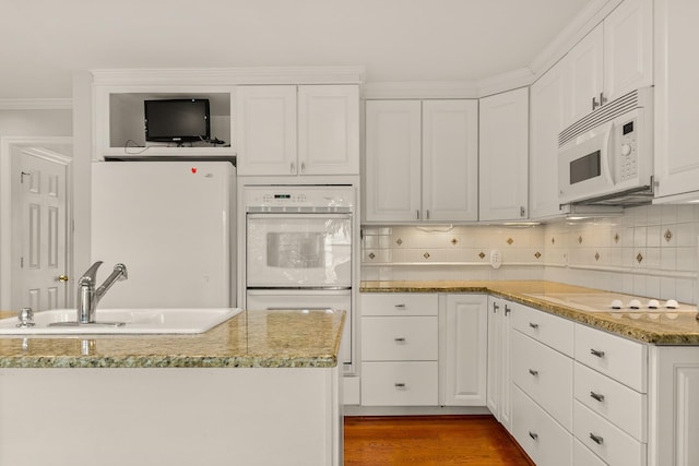 kitchen with a sink, white cabinetry, and white appliances