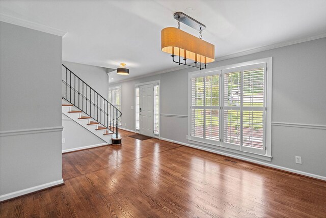 interior space with crown molding, baseboards, stairway, and wood finished floors