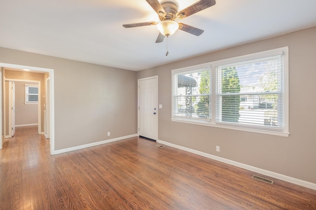 unfurnished room featuring visible vents, baseboards, ceiling fan, and wood finished floors