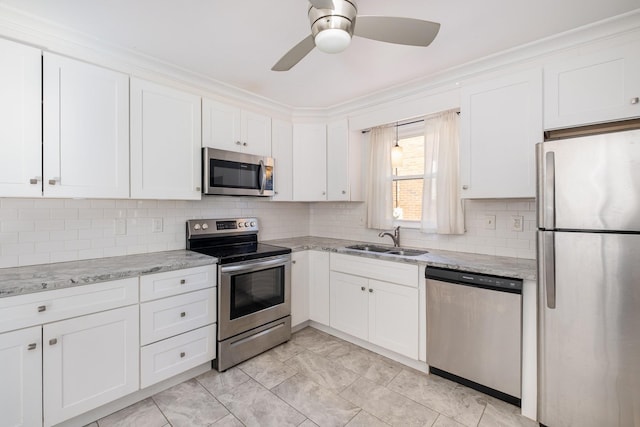 kitchen with a ceiling fan, tasteful backsplash, a sink, white cabinets, and stainless steel appliances