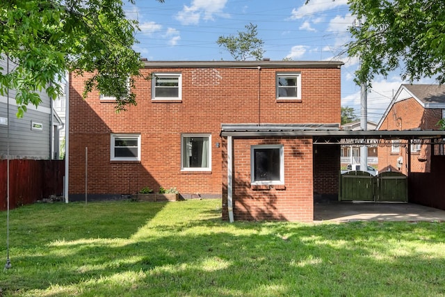 rear view of property featuring brick siding, a lawn, and fence