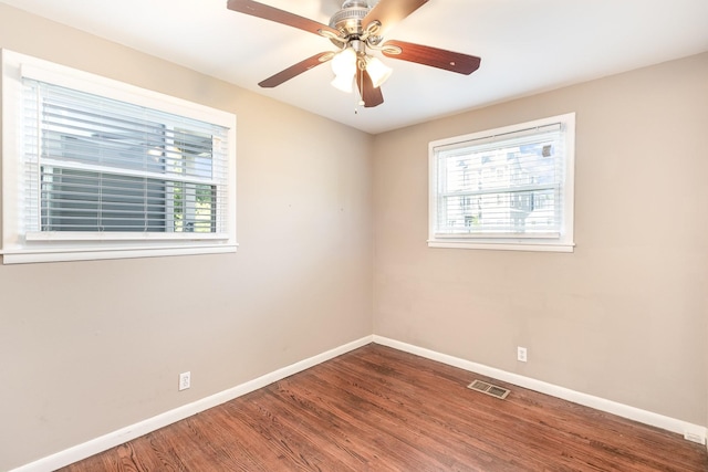 unfurnished room featuring visible vents, a ceiling fan, baseboards, and wood finished floors