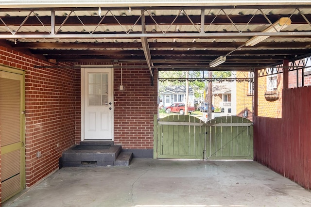 doorway to property with brick siding, a gate, and fence