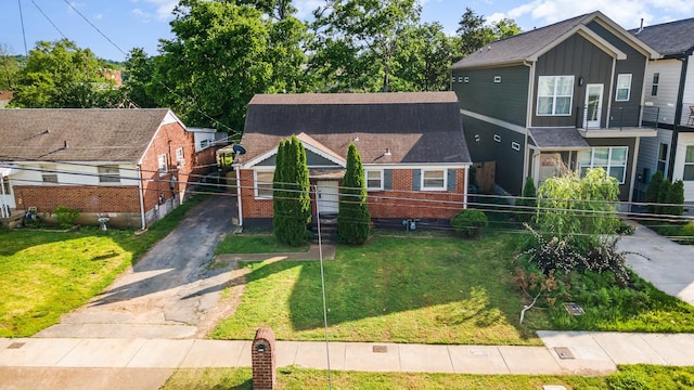 view of front of home with fence, a front yard, aphalt driveway, and brick siding