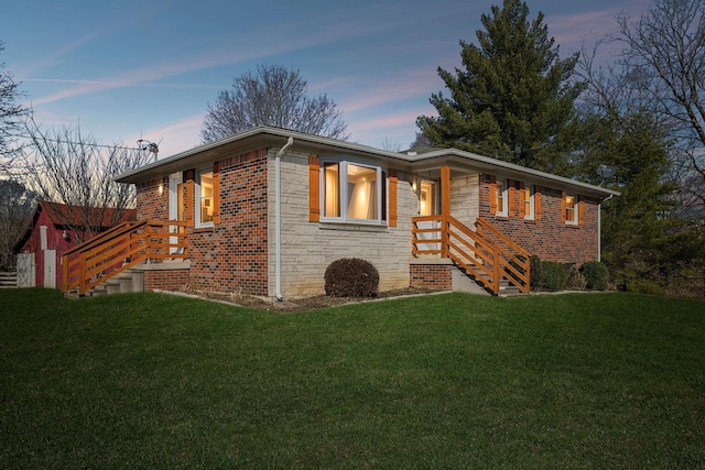 view of front facade featuring brick siding, stone siding, and a front lawn