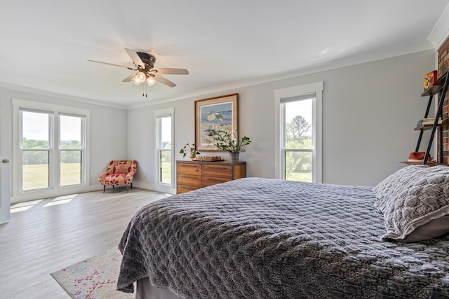 bedroom featuring ornamental molding, multiple windows, and wood finished floors