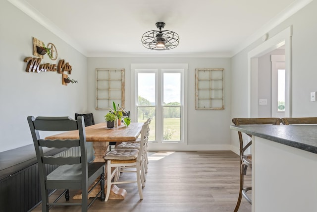 dining area with crown molding, baseboards, and wood finished floors