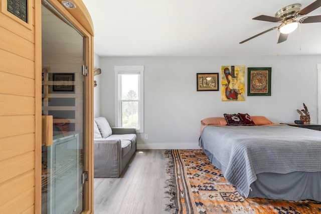 bedroom featuring a ceiling fan, baseboards, and wood finished floors