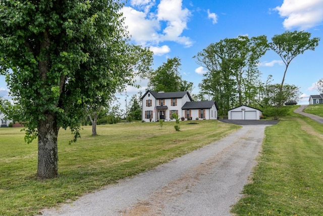 colonial home featuring a detached garage, an outbuilding, and a front yard