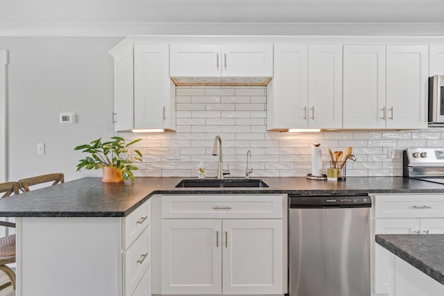 kitchen featuring white cabinets, stainless steel appliances, dark countertops, and a sink