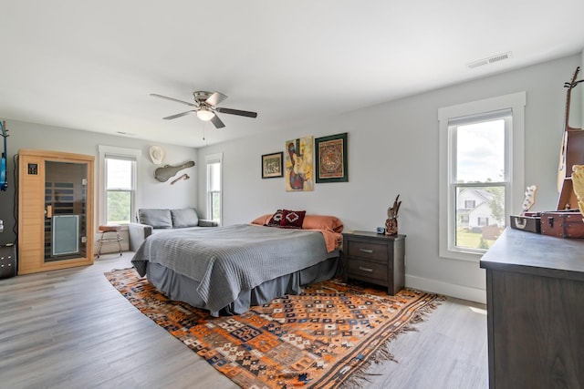 bedroom with visible vents, baseboards, ceiling fan, and light wood-type flooring