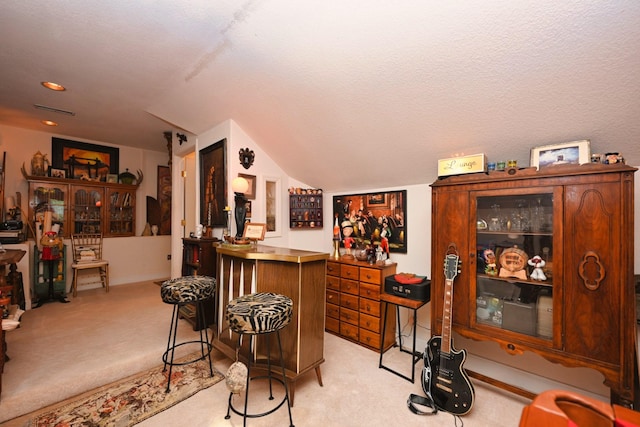 bar featuring light carpet, a bar, and lofted ceiling
