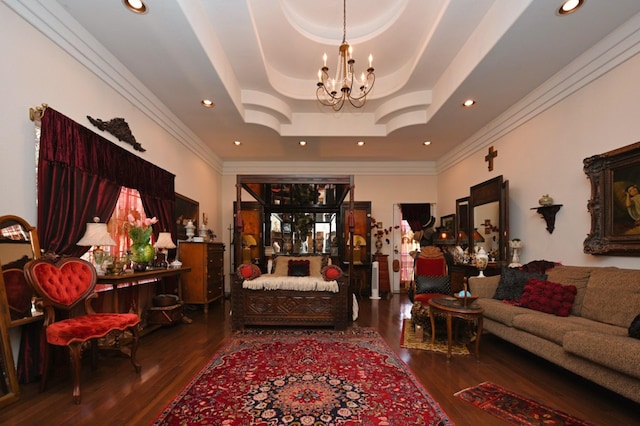 living area with an inviting chandelier, ornamental molding, wood finished floors, recessed lighting, and a tray ceiling