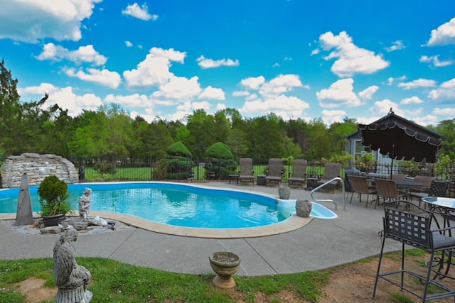 view of swimming pool featuring a fenced in pool, fence, and a patio