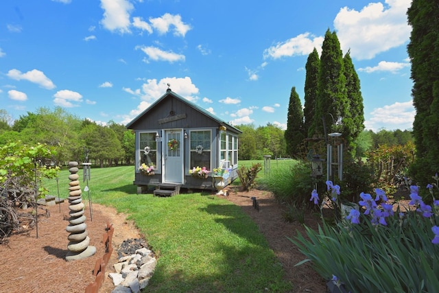 back of property with an outbuilding and a yard