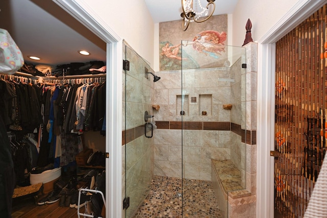 bathroom with a walk in closet, a shower stall, recessed lighting, and wood finished floors