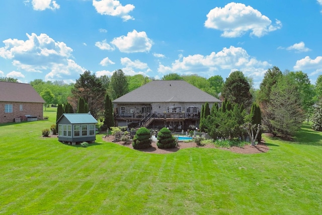 back of house with a lawn, an outdoor structure, stairway, and a deck