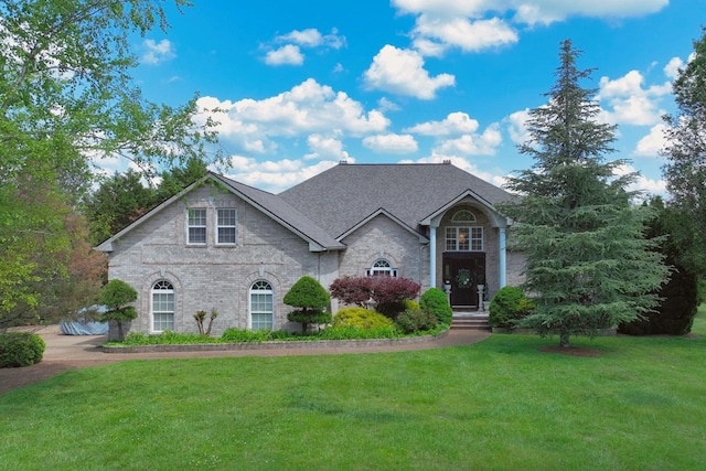 view of front of home with a front lawn and stone siding