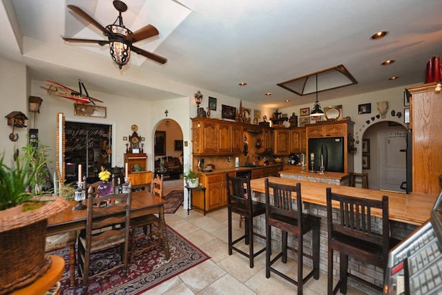 dining space featuring light tile patterned floors, arched walkways, ceiling fan, and recessed lighting