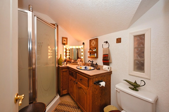 bathroom with vanity, a textured ceiling, a stall shower, and vaulted ceiling