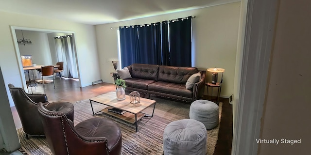 living room featuring baseboards, wood finished floors, and a notable chandelier