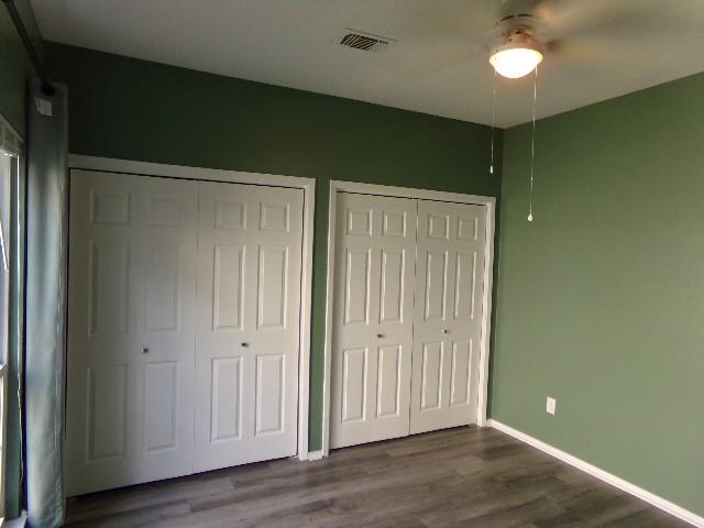 801 Laurel Hill Dr Unit 801, Old Hickory, TN 37138 - unfurnished bedroom featuring a ceiling fan, visible vents, baseboards, dark wood-style floors, and multiple closets