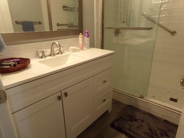801 Laurel Hill Dr Unit 801, Old Hickory, TN 37138 - full bathroom featuring vanity, decorative backsplash, and a stall shower