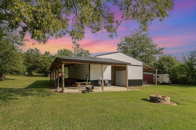 195 Spring Creek Ln, Lebanon, TN 37090 - back of property at dusk with a lawn, a pole building, an outdoor structure, and an outdoor fire pit