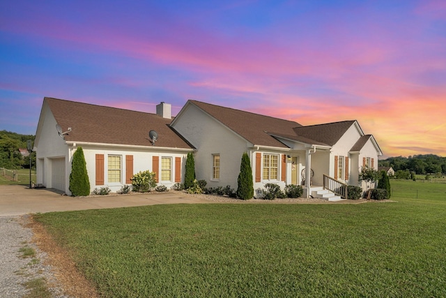 195 Spring Creek Ln, Lebanon, TN 37090 - ranch-style house with a chimney, a yard, an attached garage, concrete driveway, and stucco siding