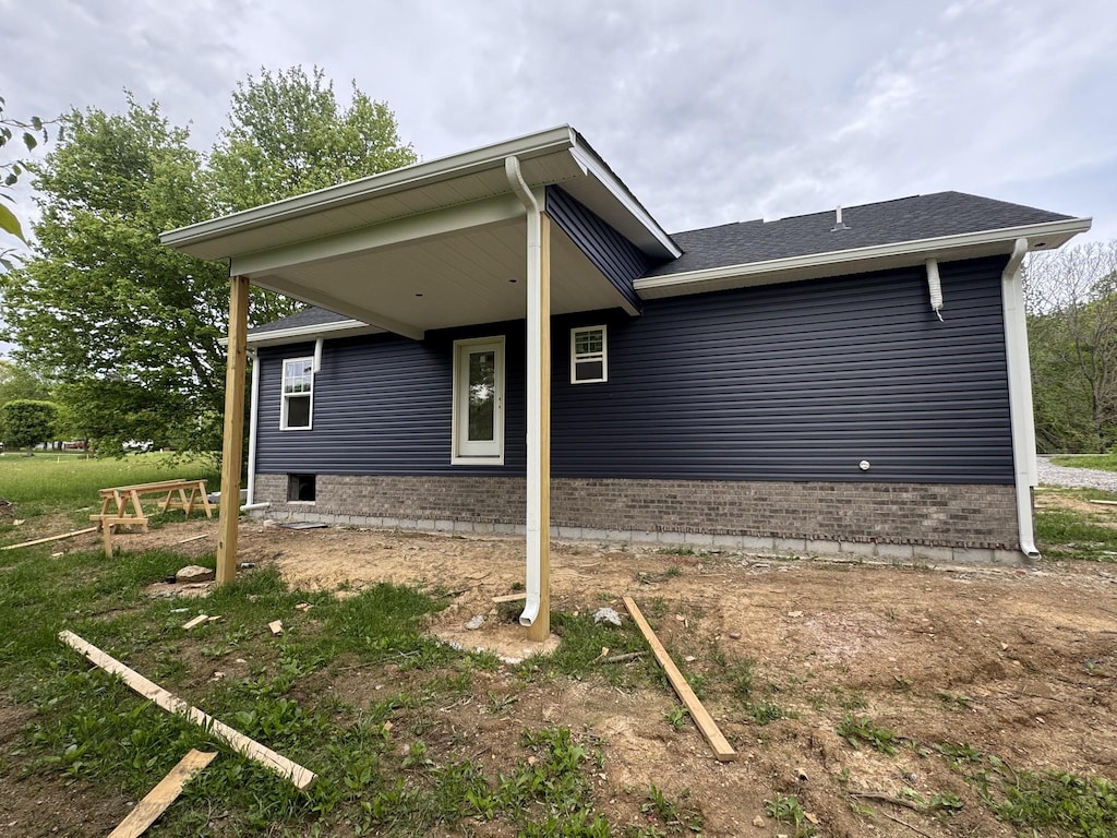 view of front facade with brick siding and a shingled roof