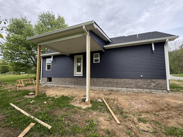 view of front facade with brick siding and a shingled roof