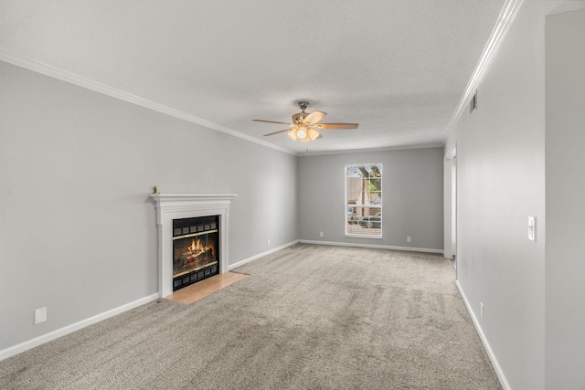 unfurnished living room with ceiling fan, a textured ceiling, a fireplace with flush hearth, ornamental molding, and carpet