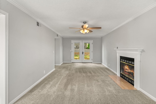 unfurnished living room featuring a ceiling fan, french doors, visible vents, a fireplace with flush hearth, and carpet floors