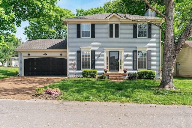 colonial inspired home featuring a front yard, roof with shingles, a chimney, an attached garage, and driveway