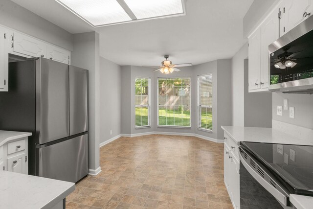 kitchen with light countertops, stainless steel appliances, a ceiling fan, and white cabinets
