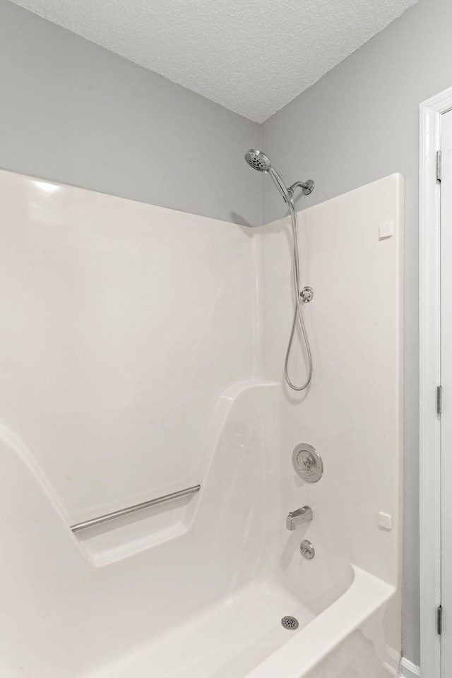 bathroom featuring a textured ceiling and shower / bathing tub combination