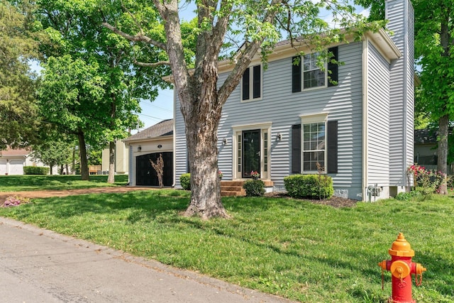 colonial-style house featuring a garage, a front lawn, and a chimney
