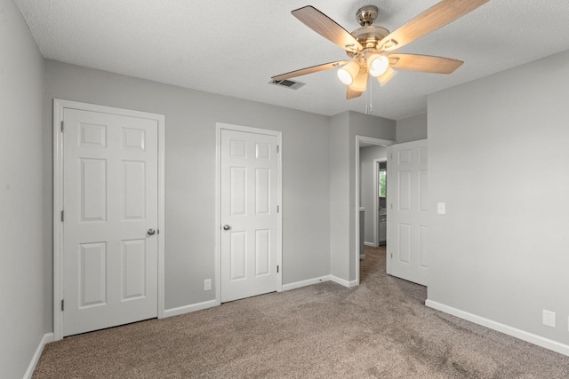 unfurnished bedroom with visible vents, carpet flooring, baseboards, and ceiling fan
