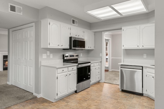 kitchen with light countertops, stainless steel appliances, visible vents, and white cabinetry
