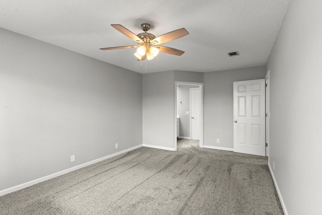 unfurnished bedroom featuring visible vents, a textured ceiling, baseboards, and carpet floors
