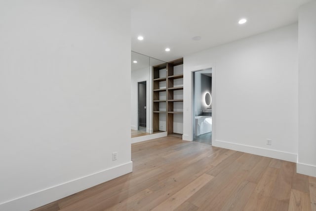 spare room featuring light wood-style floors, baseboards, and recessed lighting