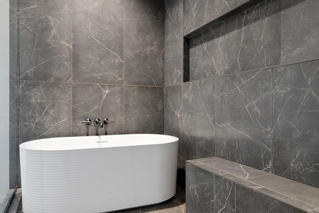 bathroom with a freestanding bath and tile walls