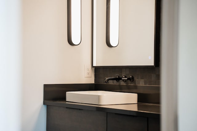 bathroom with vanity and tasteful backsplash