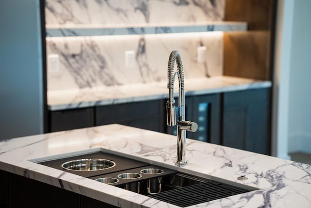 interior details with a sink and light stone counters